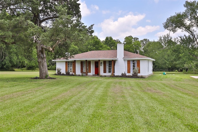 1137 Jones Rd, New Waverly, TX 77358 - ranch-style house featuring a chimney, a front lawn, and view of scattered trees