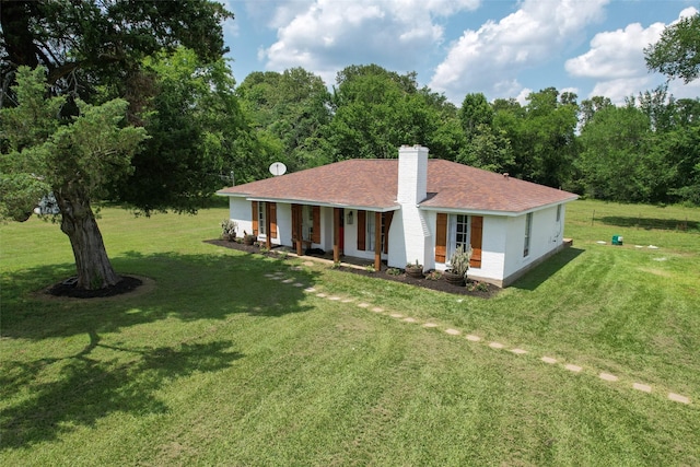 1137 Jones Rd, New Waverly, TX 77358 - back of house featuring a chimney, a lawn, covered porch, and a shingled roof