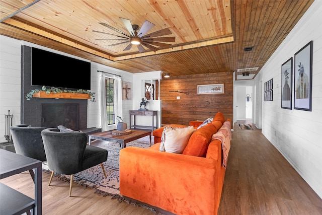 1137 Jones Rd, New Waverly, TX 77358 - living area featuring wood walls, wood ceiling, wood finished floors, a fireplace, and ceiling fan
