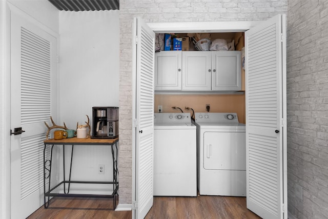 1137 Jones Rd, New Waverly, TX 77358 - laundry area featuring cabinet space, independent washer and dryer, dark wood-style floors, and brick wall