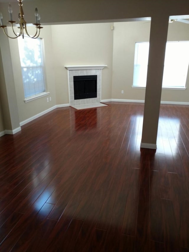 3502 Sheldon Dr, Pearland, TX 77584 - unfurnished living room with dark wood-type flooring, a chandelier, and a tile fireplace