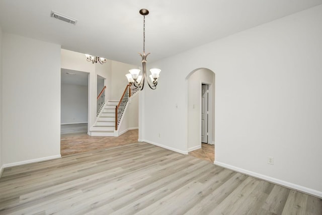 26122 Salt Creek Ln, Katy, TX 77494 - unfurnished room featuring a chandelier, light wood-style floors, arched walkways, baseboards, and stairs