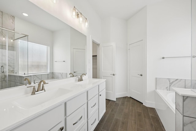 19265 Hazel Firs Ct, Magnolia, TX 77355 - bathroom with a garden tub, double vanity, wood finished floors, and a shower stall