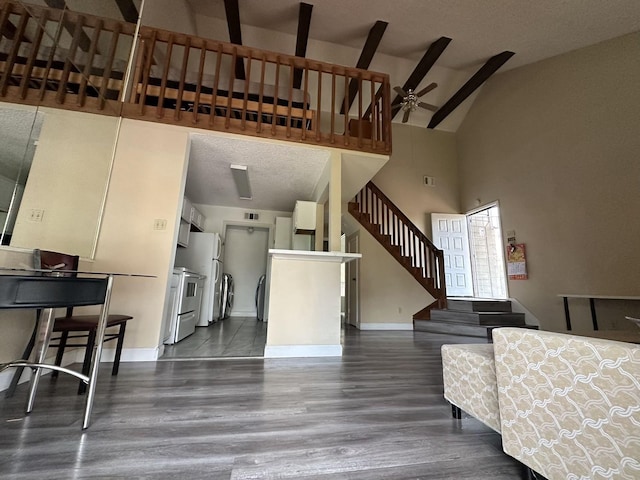 8443 Sands Point Dr, Houston, TX 77036 - living area featuring stairs, ceiling fan, dark wood finished floors, high vaulted ceiling, and washer and clothes dryer