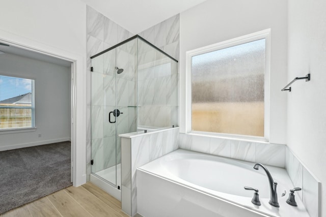 21517 Witham Promenade Ln, Magnolia, TX 77355 - bathroom featuring a garden tub, a marble finish shower, and wood finished floors