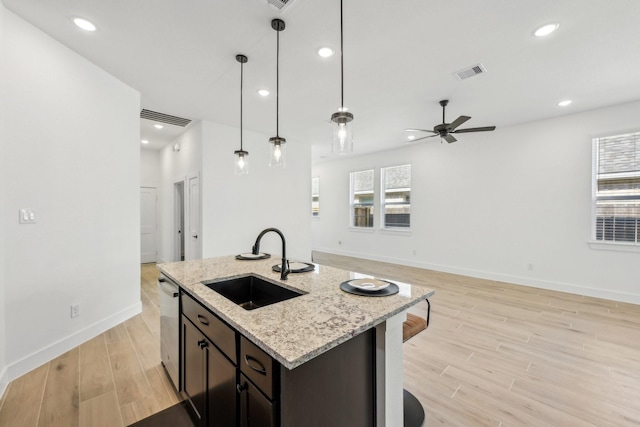 21517 Witham Promenade Ln, Magnolia, TX 77355 - kitchen featuring a sink, open floor plan, light wood-type flooring, a ceiling fan, and baseboards