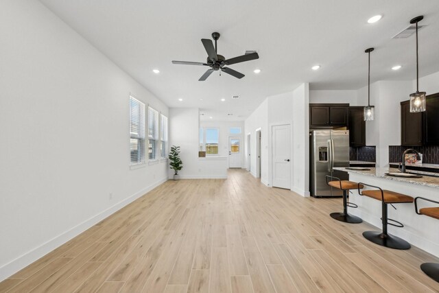 21517 Witham Promenade Ln, Magnolia, TX 77355 - unfurnished living room featuring light wood-style floors, ceiling fan, recessed lighting, and baseboards