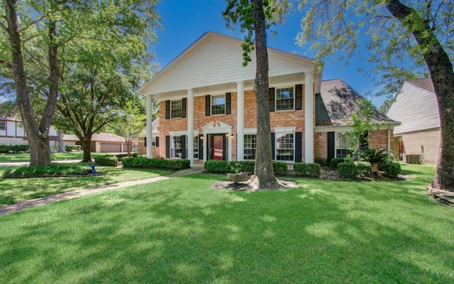 12103 Moorcreek Dr, Houston, TX 77070 - greek revival inspired property featuring brick siding, a front lawn, and central air condition unit
