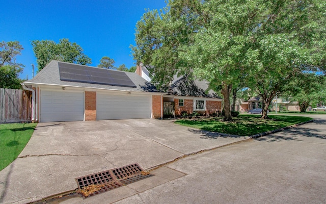 12103 Moorcreek Dr, Houston, TX 77070 - view of front of home with roof mounted solar panels, brick siding, an attached garage, driveway, and roof with shingles