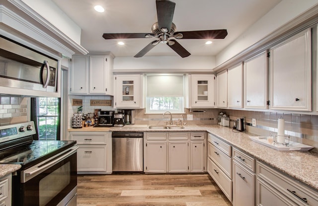 12103 Moorcreek Dr, Houston, TX 77070 - kitchen featuring appliances with stainless steel finishes, a sink, tasteful backsplash, a ceiling fan, and recessed lighting