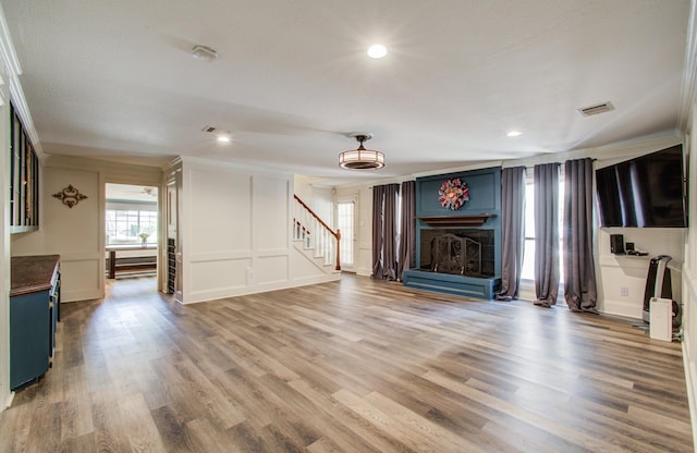 12103 Moorcreek Dr, Houston, TX 77070 - unfurnished living room with a decorative wall, crown molding, stairs, wood finished floors, and recessed lighting