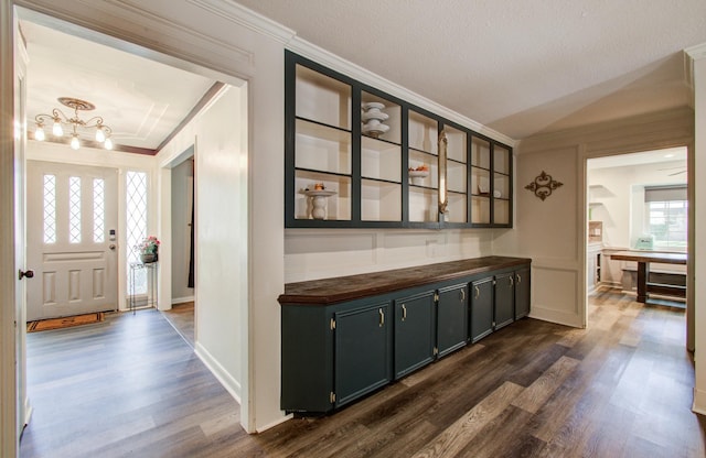 12103 Moorcreek Dr, Houston, TX 77070 - bar with crown molding, dark wood-style flooring, and a chandelier