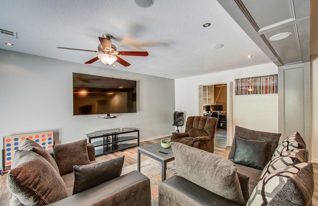 12103 Moorcreek Dr, Houston, TX 77070 - living area with wood finished floors, a ceiling fan, baseboards, a textured ceiling, and recessed lighting