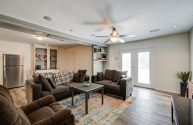 12103 Moorcreek Dr, Houston, TX 77070 - living area with a textured ceiling, a ceiling fan, light wood finished floors, baseboards, and french doors