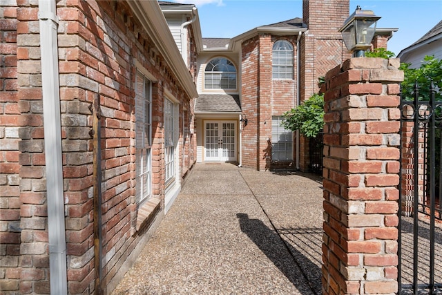 926 Montview Dr, Katy, TX 77450 - view of side of property featuring french doors, brick siding, and a chimney