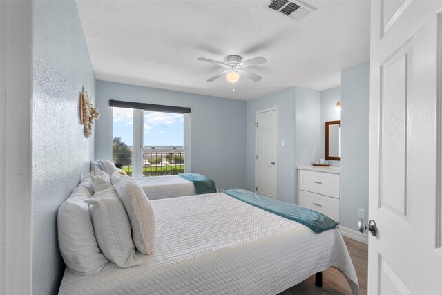 7600 Seawall Blvd Unit 109, Galveston, TX 77551 - bedroom featuring wood finished floors, ceiling fan, baseboards, and a textured ceiling