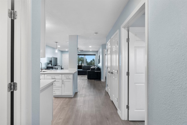 7600 Seawall Blvd Unit 109, Galveston, TX 77551 - hallway featuring a textured wall, light wood-type flooring, and a sink
