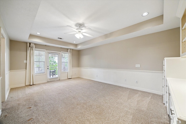 4911 Shiloh Lake Dr, Richmond, TX 77407 - empty room featuring ceiling fan, light carpet, a wainscoted wall, a raised ceiling, and recessed lighting