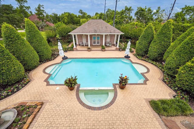 4911 Shiloh Lake Dr, Richmond, TX 77407 - view of pool featuring a patio area, an exterior structure, an outbuilding, view of scattered trees, and a pool with connected hot tub
