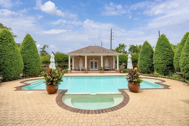 4911 Shiloh Lake Dr, Richmond, TX 77407 - view of pool featuring a pool with connected hot tub, a patio area, a storage structure, and an outbuilding