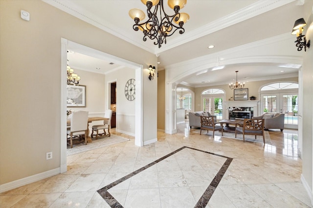 4911 Shiloh Lake Dr, Richmond, TX 77407 - foyer entrance featuring a chandelier, arched walkways, baseboards, ornamental molding, and a fireplace