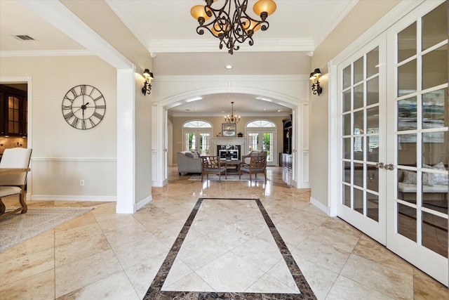 4911 Shiloh Lake Dr, Richmond, TX 77407 - foyer featuring a chandelier, french doors, arched walkways, crown molding, and baseboards