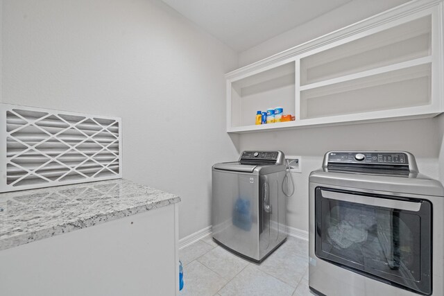 19918 Lizzie Ridge Ln, Cypress, TX 77433 - laundry room featuring washing machine and clothes dryer, light tile patterned floors, and baseboards