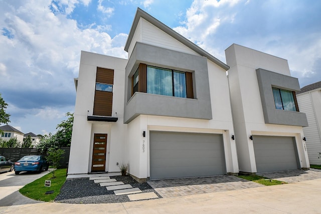 7603 Jacquelyn Gardens Ln, Houston, TX 77055 - contemporary house featuring stucco siding, decorative driveway, and an attached garage