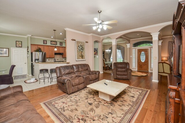 1511 Baldridge Ln, Katy, TX 77494 - living area with decorative columns, arched walkways, ceiling fan, ornamental molding, and light wood finished floors