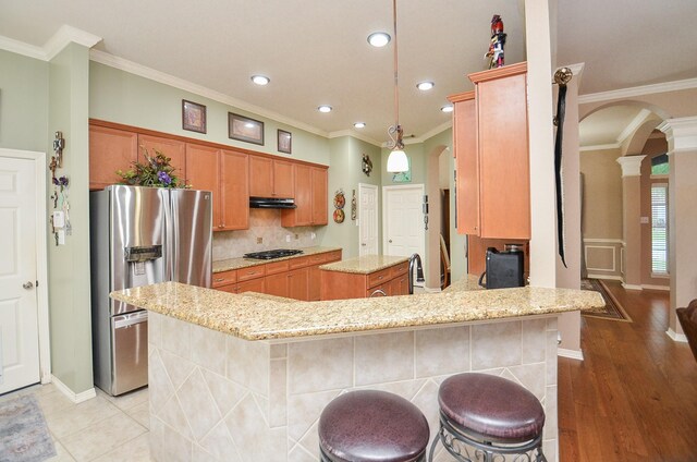 1511 Baldridge Ln, Katy, TX 77494 - kitchen featuring stainless steel fridge, arched walkways, crown molding, a center island, and black gas cooktop