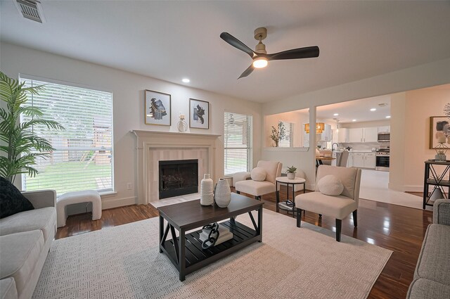 5615 Haven Point Dr, Houston, TX 77084 - living area with ceiling fan, dark wood-style flooring, a tiled fireplace, recessed lighting, and baseboards
