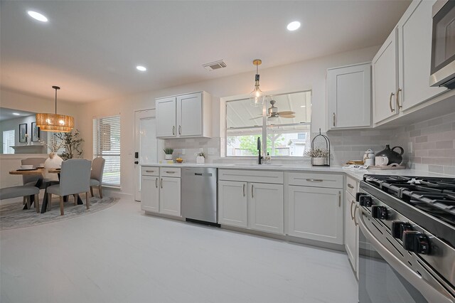 5615 Haven Point Dr, Houston, TX 77084 - kitchen featuring stainless steel appliances, a sink, tasteful backsplash, light countertops, and pendant lighting