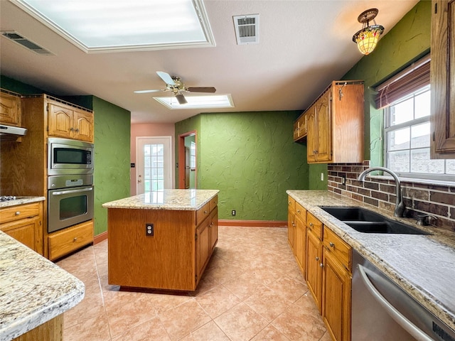1507 N 24th St, Nederland, TX 77627 - kitchen with appliances with stainless steel finishes, a sink, a textured wall, a kitchen island, and plenty of natural light