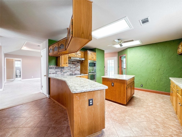 1507 N 24th St, Nederland, TX 77627 - kitchen featuring stainless steel appliances, a center island, under cabinet range hood, baseboards, and light tile patterned floors