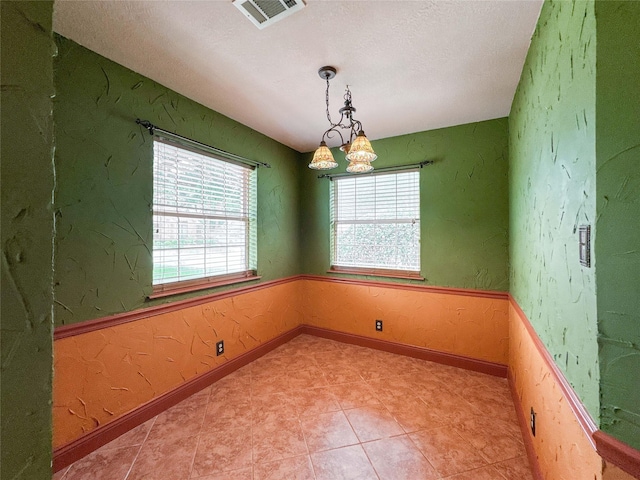 1507 N 24th St, Nederland, TX 77627 - empty room with healthy amount of natural light, a chandelier, baseboards, and a textured ceiling