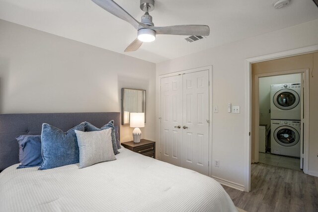 2703 Jackson St, Houston, TX 77004 - bedroom featuring stacked washer / drying machine, a closet, wood finished floors, ceiling fan, and baseboards