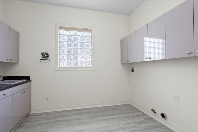 7123 Broadway St, Galveston, TX 77554 - laundry area with hookup for a gas dryer, light wood-style flooring, washer hookup, baseboards, and cabinet space