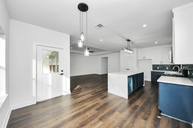 7430 Avenue E Ave E, Beasley, TX 77417 - kitchen with stainless steel microwave, hanging light fixtures, dark wood finished floors, tasteful backsplash, and recessed lighting