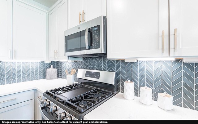 418 Riesling Dr, Alvin, TX 77511 - kitchen featuring stainless steel appliances, light countertops, white cabinets, and tasteful backsplash