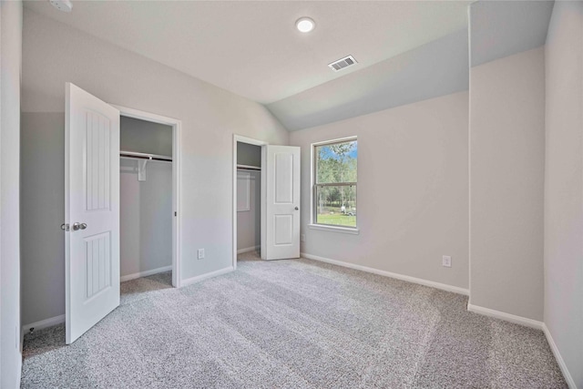 1497 Rd 66114, Dayton, TX 77535 - unfurnished bedroom with two closets, carpet floors, and vaulted ceiling
