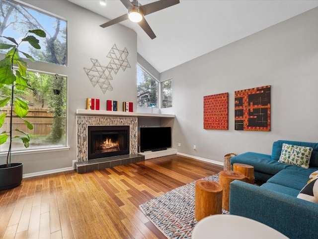 10 Leaf Trace Ct, The Woodlands, TX 77381 - living room with high vaulted ceiling, a tile fireplace, a ceiling fan, and wood finished floors