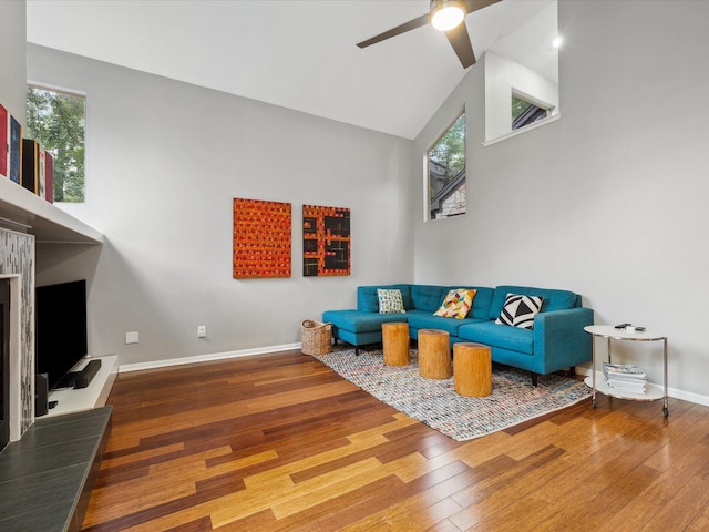 10 Leaf Trace Ct, The Woodlands, TX 77381 - living area with wood finished floors, a ceiling fan, healthy amount of natural light, a fireplace with raised hearth, and high vaulted ceiling