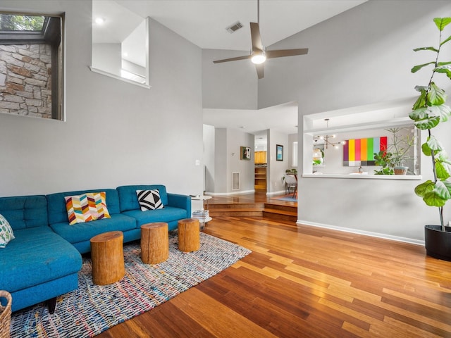 10 Leaf Trace Ct, The Woodlands, TX 77381 - living area featuring wood finished floors, a ceiling fan, a chandelier, and a high ceiling
