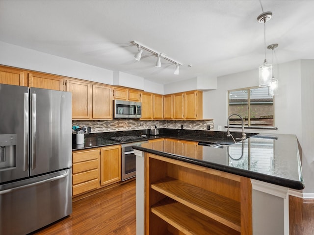 10 Leaf Trace Ct, The Woodlands, TX 77381 - kitchen with stainless steel appliances, backsplash, dark wood-style floors, hanging light fixtures, and dark stone counters