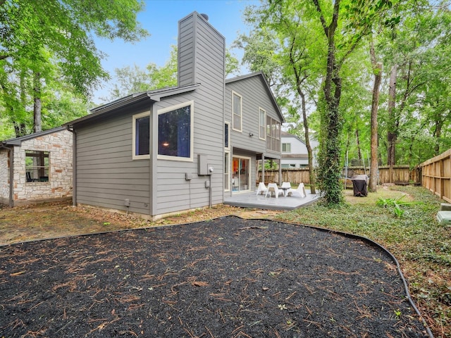 10 Leaf Trace Ct, The Woodlands, TX 77381 - back of property featuring a patio area and a chimney