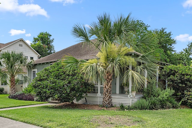 1039 Louise St, Houston, TX 77009 - view of side of property with a lawn, a shingled roof, and a porch