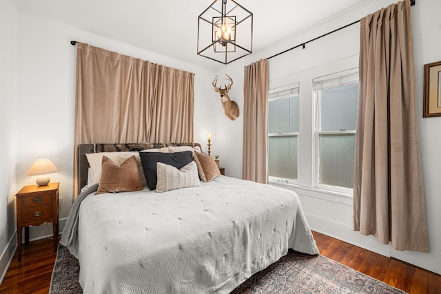 1039 Louise St, Houston, TX 77009 - bedroom featuring dark wood-type flooring, a chandelier, and baseboards
