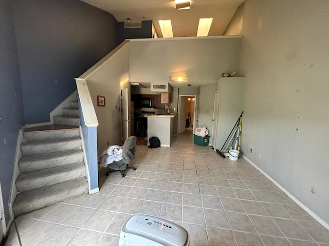 10855 Meadowglen Ln Unit 723, Houston, TX 77042 - unfurnished living room featuring light tile patterned flooring, stairs, and baseboards