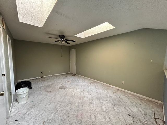 10855 Meadowglen Ln Unit 723, Houston, TX 77042 - empty room with a skylight, a textured ceiling, carpet floors, ceiling fan, and vaulted ceiling