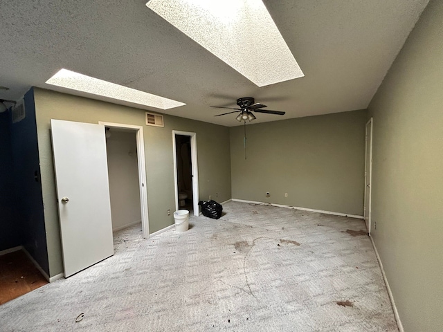 10855 Meadowglen Ln Unit 723, Houston, TX 77042 - unfurnished bedroom with a skylight, carpet flooring, baseboards, connected bathroom, and a textured ceiling